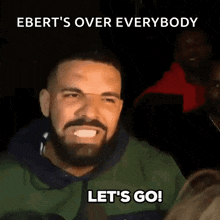 a man with a beard is making a funny face and says " let 's go "