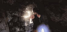 a man is standing in a dark room with a light coming out of his chest .