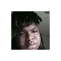 a man with dreadlocks is making a funny face while crying .