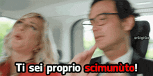 a man and a woman in a car with the words ti sei proprio scimunuto on the bottom