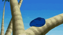 a blue object is sitting on a tree branch in a cartoon .