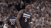 a couple of basketball players are standing next to each other on a court .