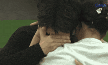 a woman covering a man 's face with her hands with gma written on the bottom