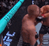 two men are fighting in a boxing ring with a sign that says hypnotic on it .