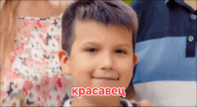 a young boy is smiling in front of a sign that says " kpacabec "