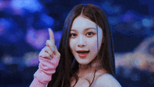 a woman with long hair is wearing a pink sweater and giving a thumbs up