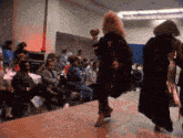 a woman with blonde hair is walking down the runway