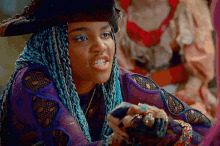 a woman with blue braids and a pirate hat