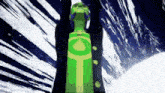 a green bottle with a yellow circle on it is in front of a blue and white background