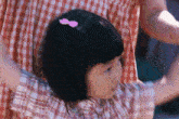 a little girl wearing a pink bow in her hair