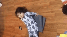 a child is playing with a yoga mat on the floor .