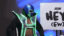 a wrestler is standing in front of an aew sign
