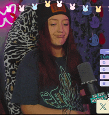 a woman giving a peace sign in front of a microphone with a leopard print chair behind her