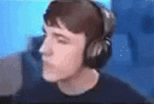 a blurry picture of a man wearing headphones and a black shirt .