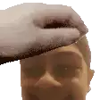 a hand is touching a man 's forehead with a foamy substance .