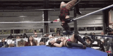 two women are wrestling in a ring with a sign that says ncw on it .
