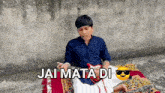 a young man is sitting on a rug with a guitar and the words " jai mata di " on the bottom