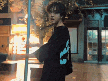 a man wearing a black shirt that says " a " on it