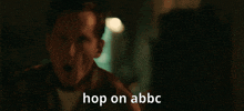 a man in a dark room with the words hop on abbc written on the bottom