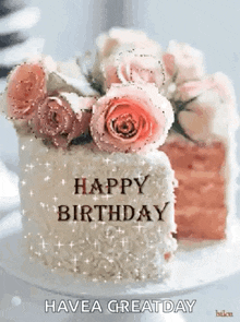 a birthday cake with pink roses on top of it and the words `` happy birthday '' written on it .