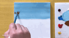 a person is painting on a canvas with the words made in animatica on the bottom right