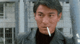 a man in a black leather jacket is smoking a cigarette in his mouth .