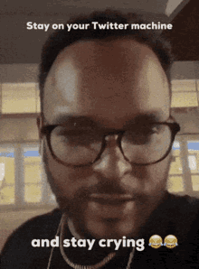 a man wearing glasses says " stay on your twitter machine "