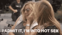 two women are sitting on a bench and one of them says " i admit it i 'm into hot sex "