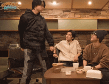 a group of people are sitting at a table with a sign that says ' sunny radio ' on it