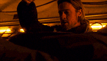 a man in a dark room is holding a gun in his right hand