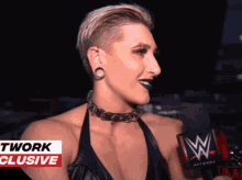 a woman is talking into a microphone with a wwe logo on it