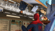 a man in a spiderman costume sits at a counter in a restaurant