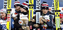 a group of skiers are posing for a photo and one of the skiers is wearing a namemo hat