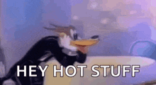 a cartoon penguin is wearing a tuxedo and saying `` hey hot stuff '' while sitting on a bed .