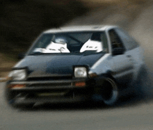a blurry picture of a car with a person in the driver 's seat wearing a helmet