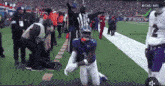 a football player with the number 2 on his jersey kneeling down on the field