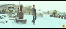 a man is standing in front of a truck at a gas station with tires in the background .