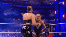 a woman is wrestling another woman in a wrestling ring during a royal rumble match .