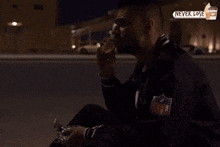 a man in a nfl jacket is eating a sandwich