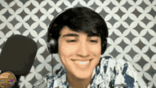 a young man wearing headphones is smiling and looking at the camera .