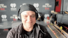 a man wearing headphones is making a funny face in front of a wall with hearts on it