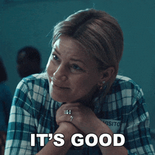 a woman in a plaid shirt with the words it 's good on her face