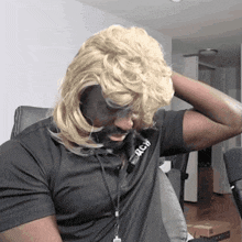 a man wearing a wig and a black shirt with the word jach on it