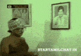 a man without a shirt is standing in front of a framed picture of a man and the words starttamilchat.in below him