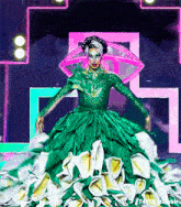 a drag queen is wearing a green dress with flowers on it .