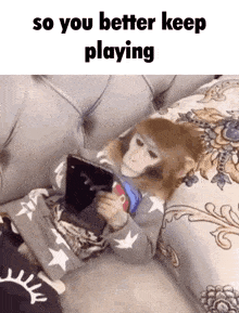a monkey laying on a couch playing a video game with the caption so you better keep playing