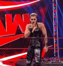 a woman is standing in a wrestling ring covering her mouth