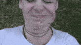 a close up of a woman 's face with her eyes closed and a necklace around her neck