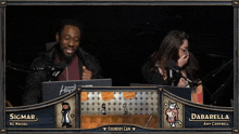 a man and a woman are sitting in front of microphones and a screen that says foundry cam on it