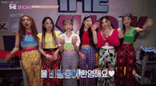 a group of girls are standing in front of a sign that says ' the show ' on it